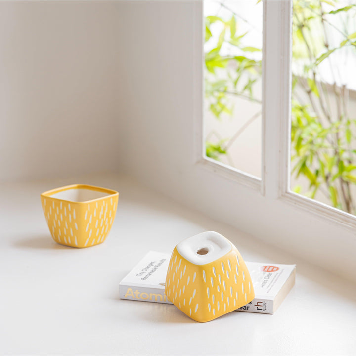 Display image of Square yellow ceramic planter with a unique teardrop pattern and a smooth matte finish.