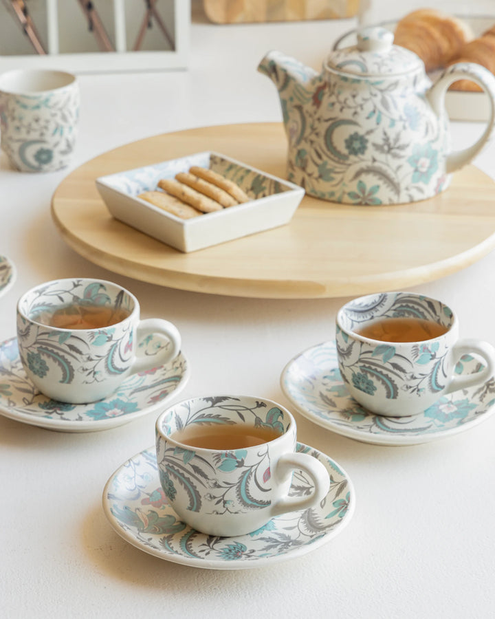 Tea set with cups, saucers, and a teapot on a table.