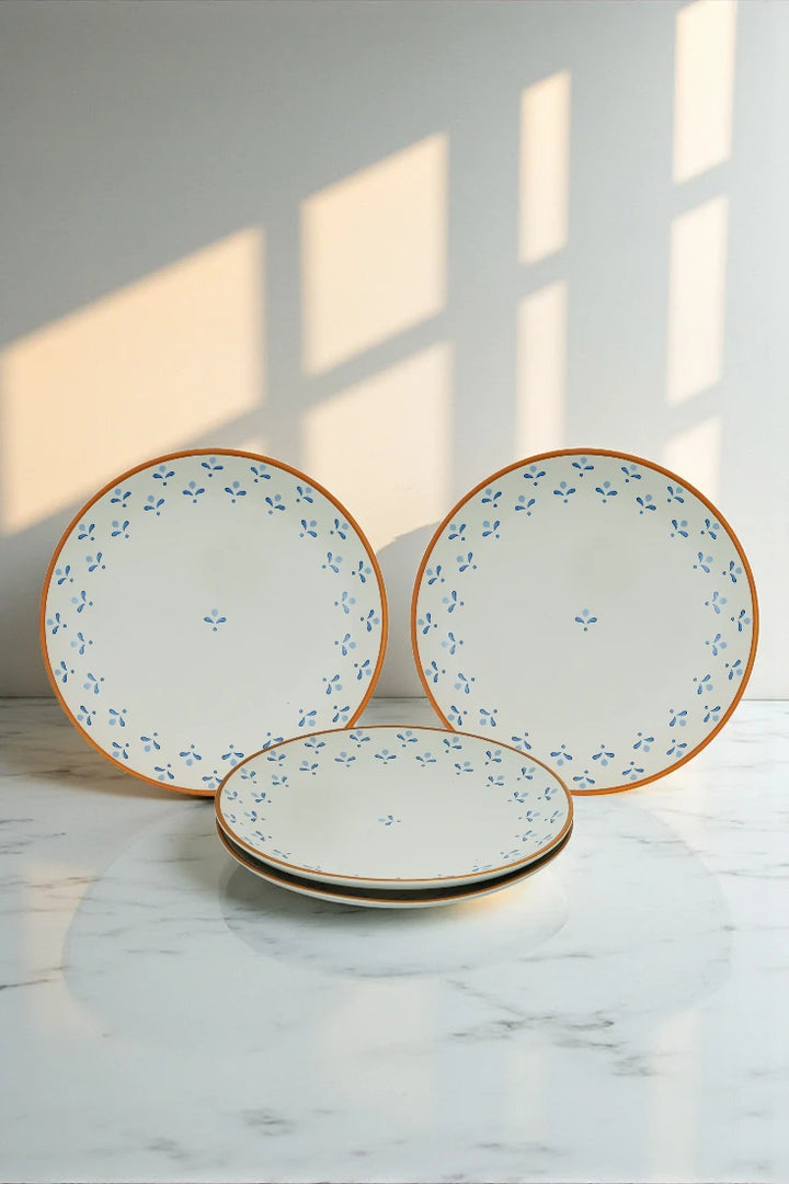 Set of three ceramic plates with floral patterns on a marble surface.