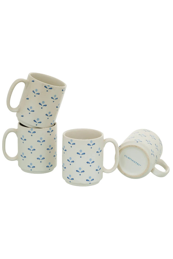 Set of four ceramic mugs with floral pattern on a white background