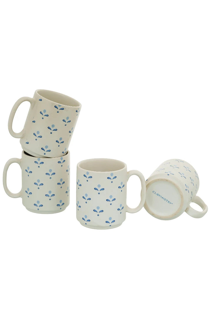 Set of four ceramic mugs with floral pattern on a white background