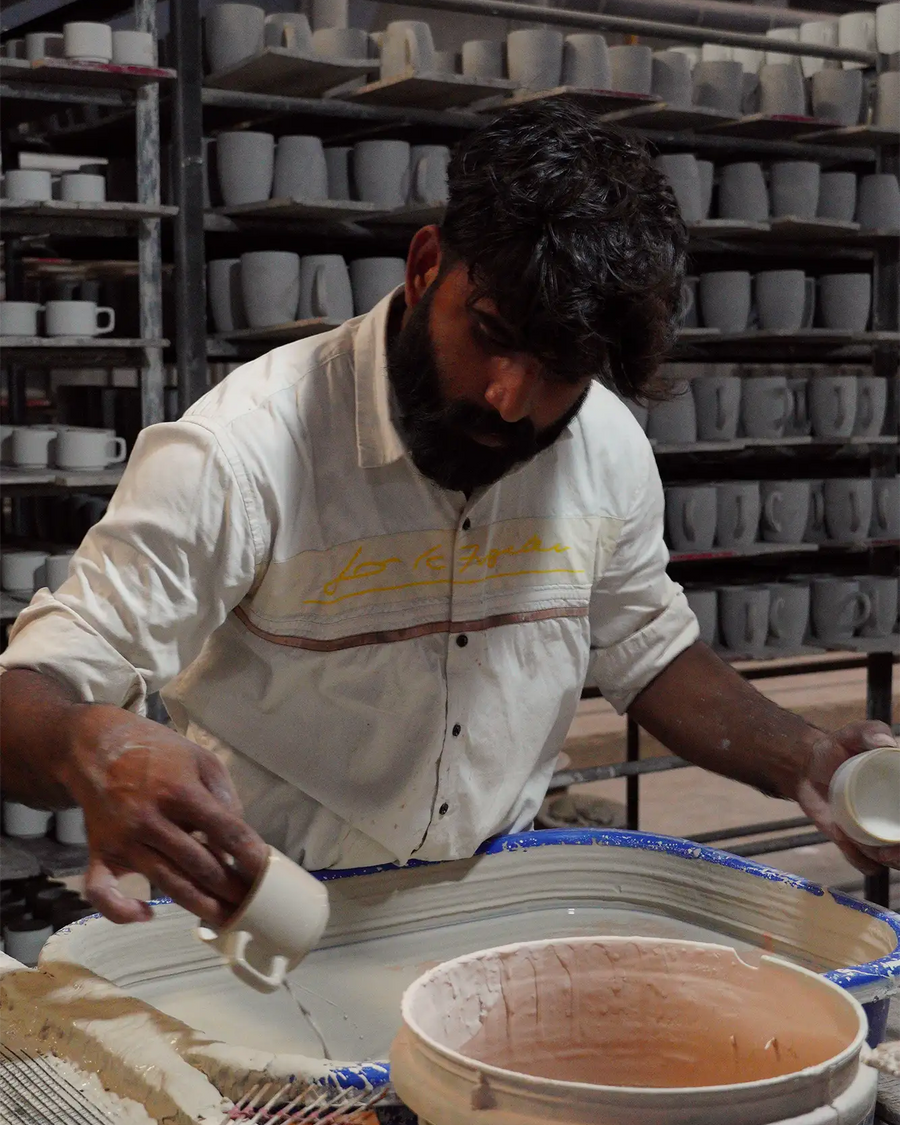 Man working with ceramic materials in a pottery workshop