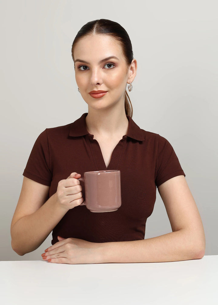 Woman holding a mug of hot chocolate against a plain background