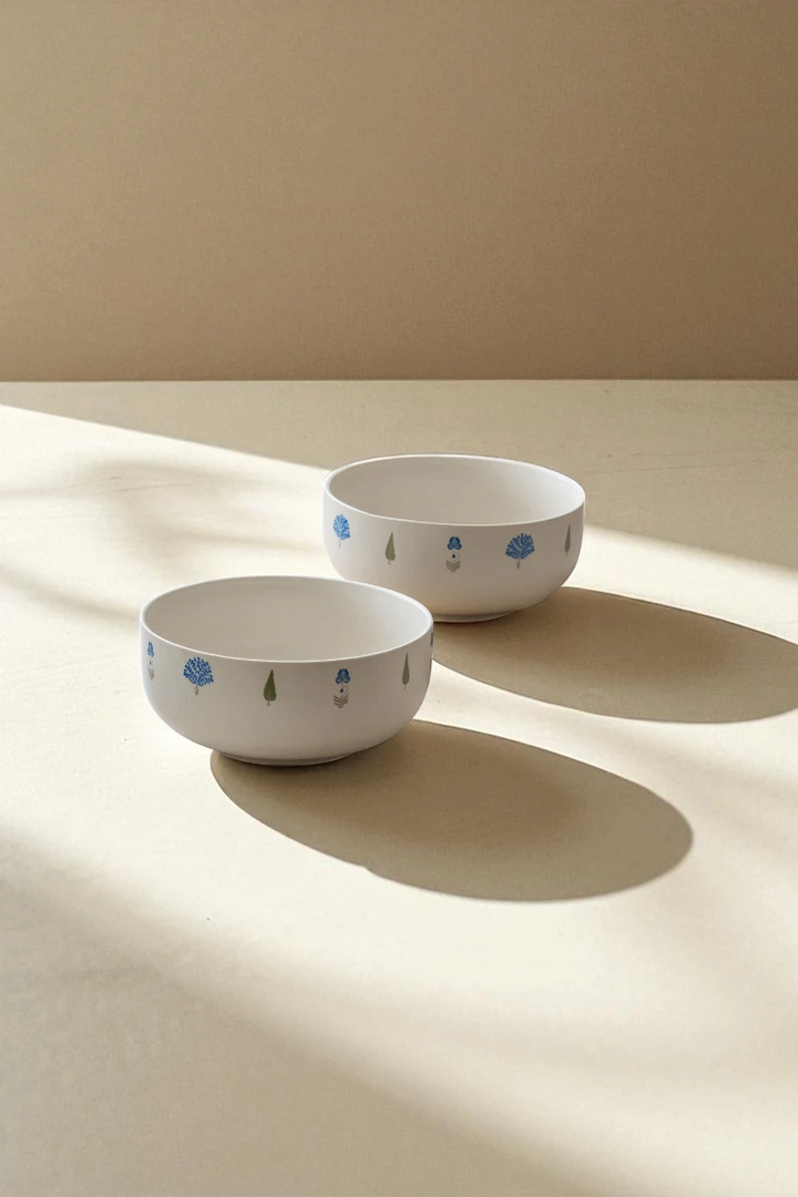 A pair of The Solitude luxury ceramic bowls with minimalist blue and green tree designs, presented on a light background with soft shadows, highlighting their clean aesthetic as ceramic decorative bowls.