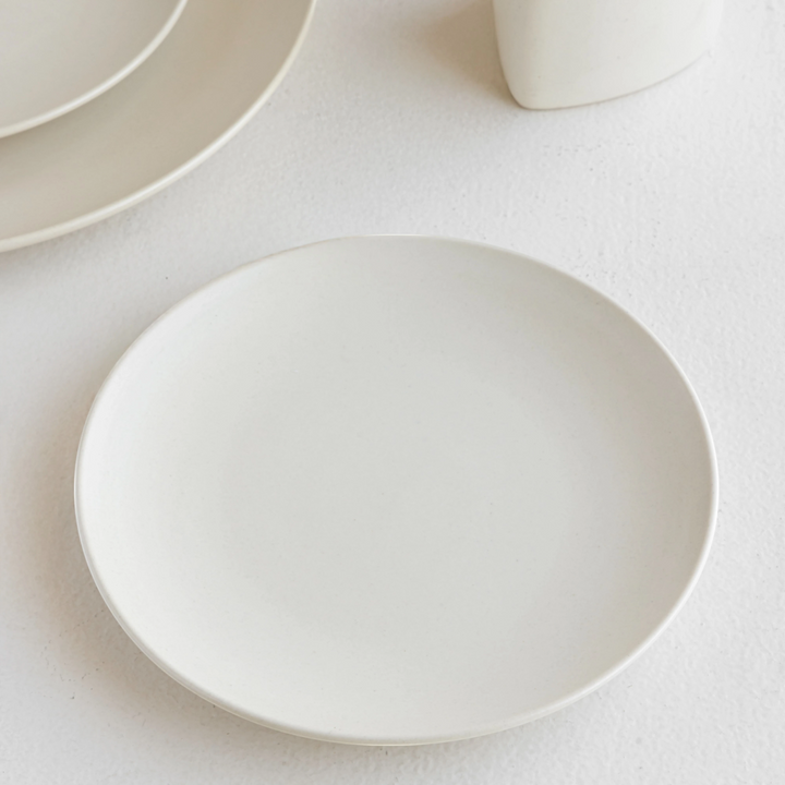 Aesthetic white ceramic side plate, bone ash-free and handcrafted for refined, modern table settings.