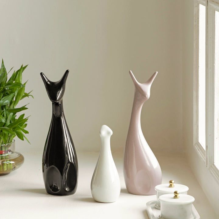 Elegant ceramic deer trio figurines with shiny glaze for aesthetic home or office decor setting.