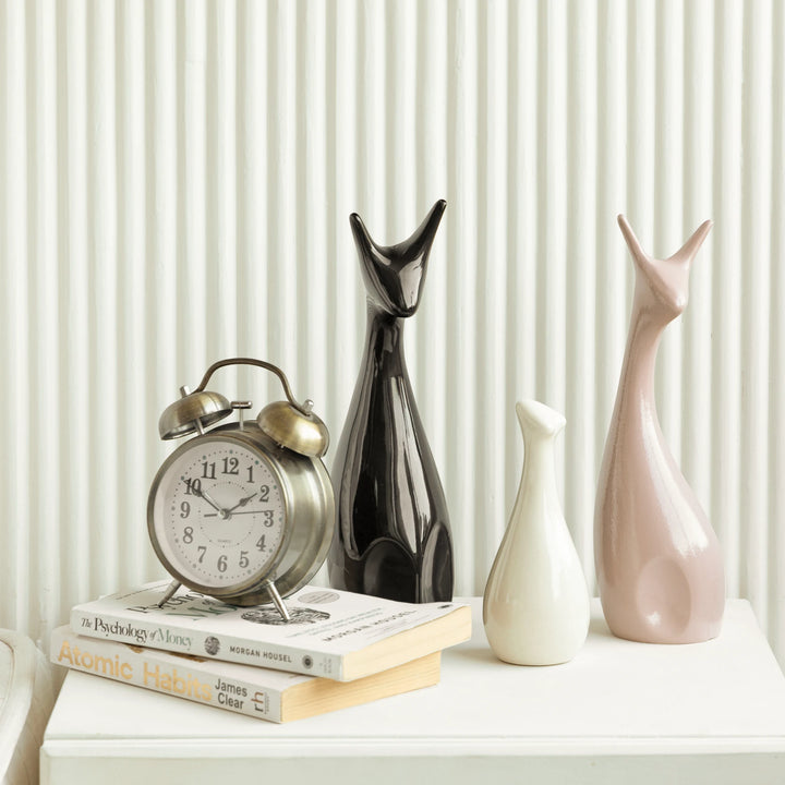 Pretty deer-shaped ceramic figurines in pink, black, and white, perfect for stylish home decor.