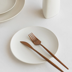 Durable white ceramic plate, safe for microwave and dishwasher, with a minimalist artisanal charm.