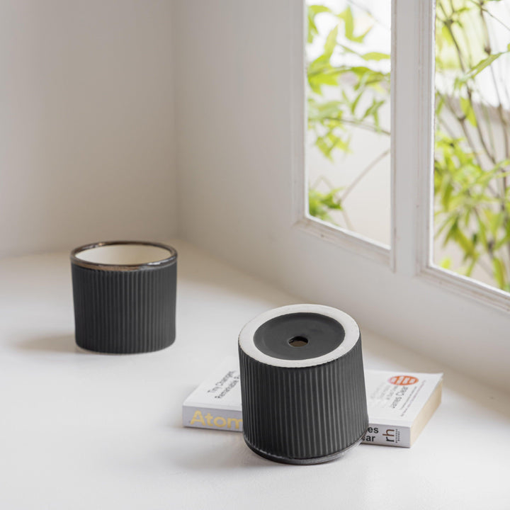 Matte black ceramic planter for air-purifying plants, sleek and modern for elegant decor.