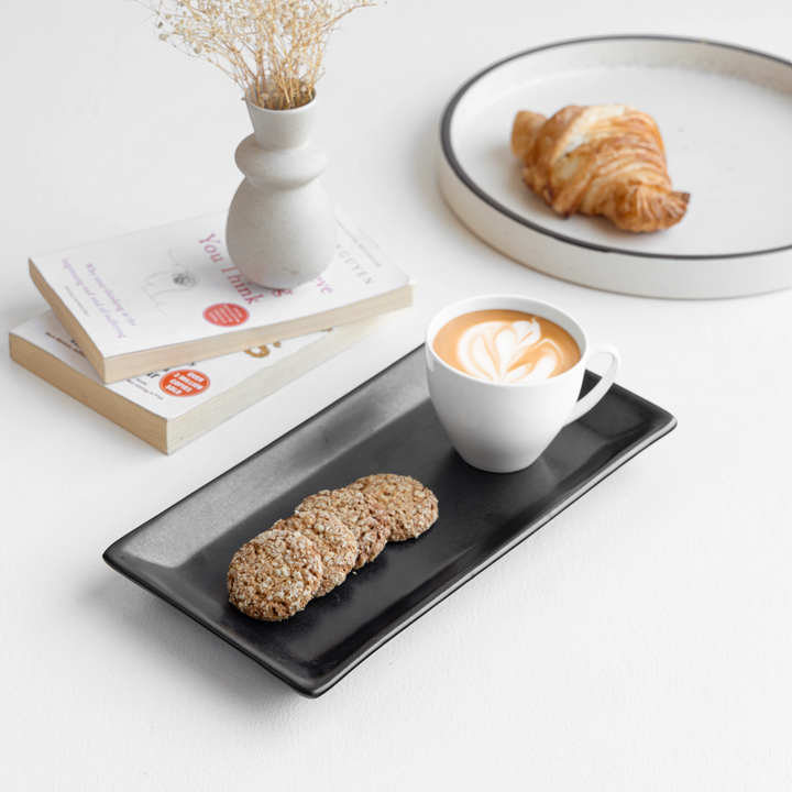 Minimalist black ceramic trays with raised edges, non-toxic and handcrafted for elegance.