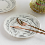 Handmade off-white ceramic dinner plate with black stripes, non-toxic and crafted for elegant dining.