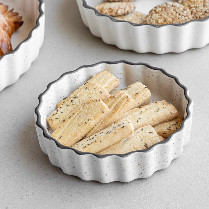 Durable white ceramic trays with raised edges and speckles, microwave safe and spill-proof.