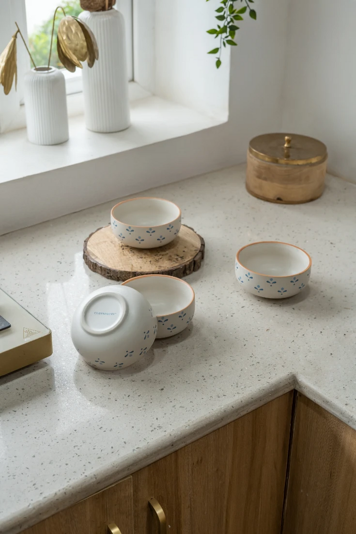 Set of ceramic bowls on a speckled countertop with decorative elements.