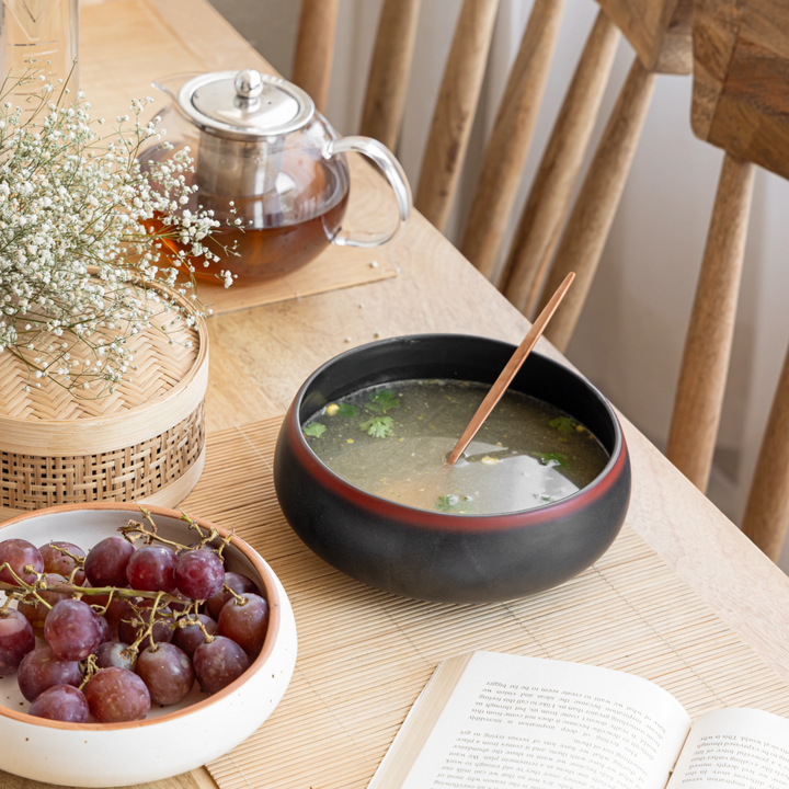 Versatile 600ml ceramic bowl in black with red rim, handcrafted and beautifully glazed.